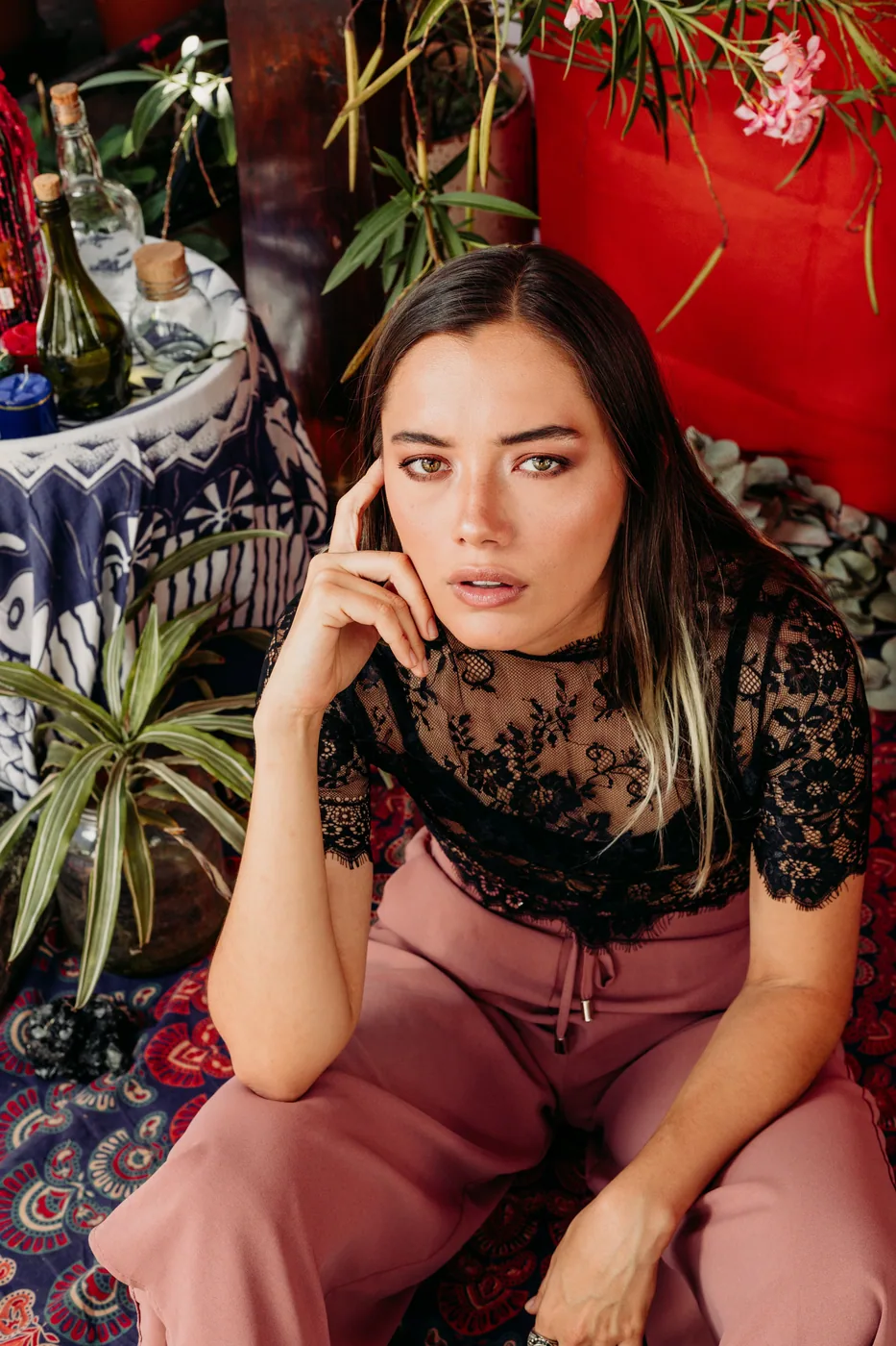 MYSTICA — full look against a red backdrop and textiles