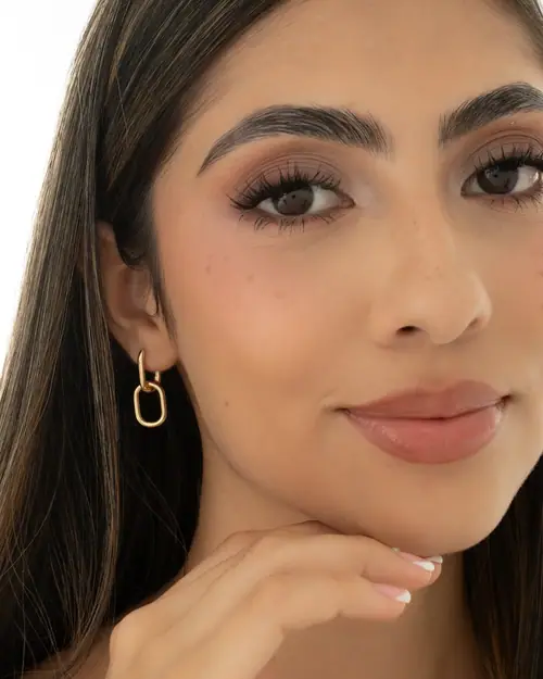 BLZ C — aretes de eslabón dorado, maquillaje glow